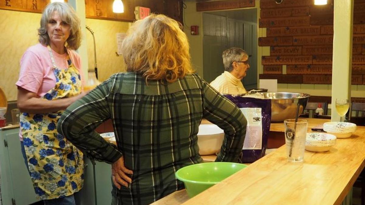 Judy Schuster, right, reports ticket sales while Ellie Brown, Cindy Pierson and Mary Woest make final preparation for service.