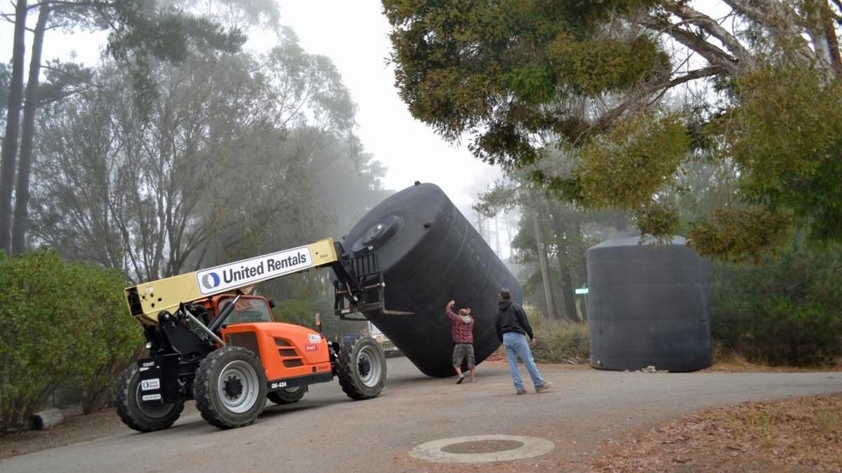 Workers roll a tank into place Tuesday as they prepare to replace the Fiscalini Water Tank on Lodge Hill.