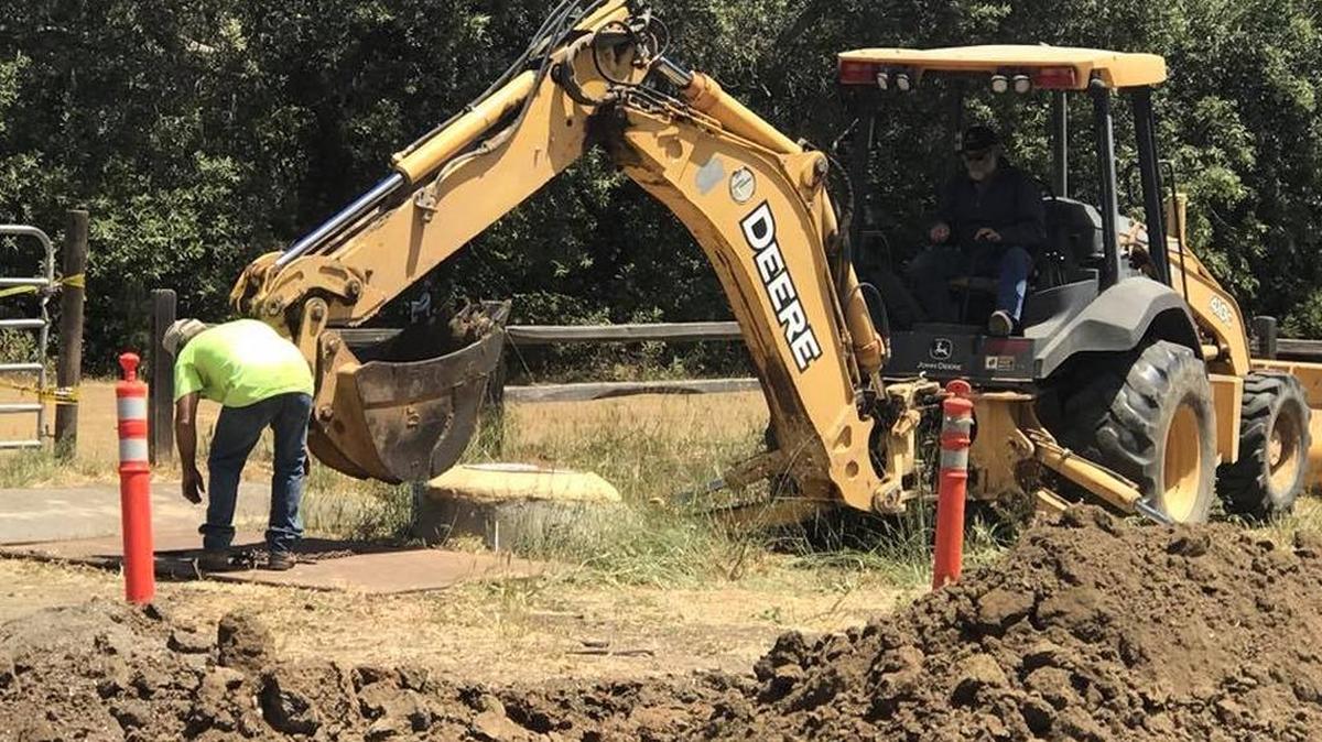 Workers use heavy equipment to dig up earth after the leak was discovered near Santa Rosa Creek.