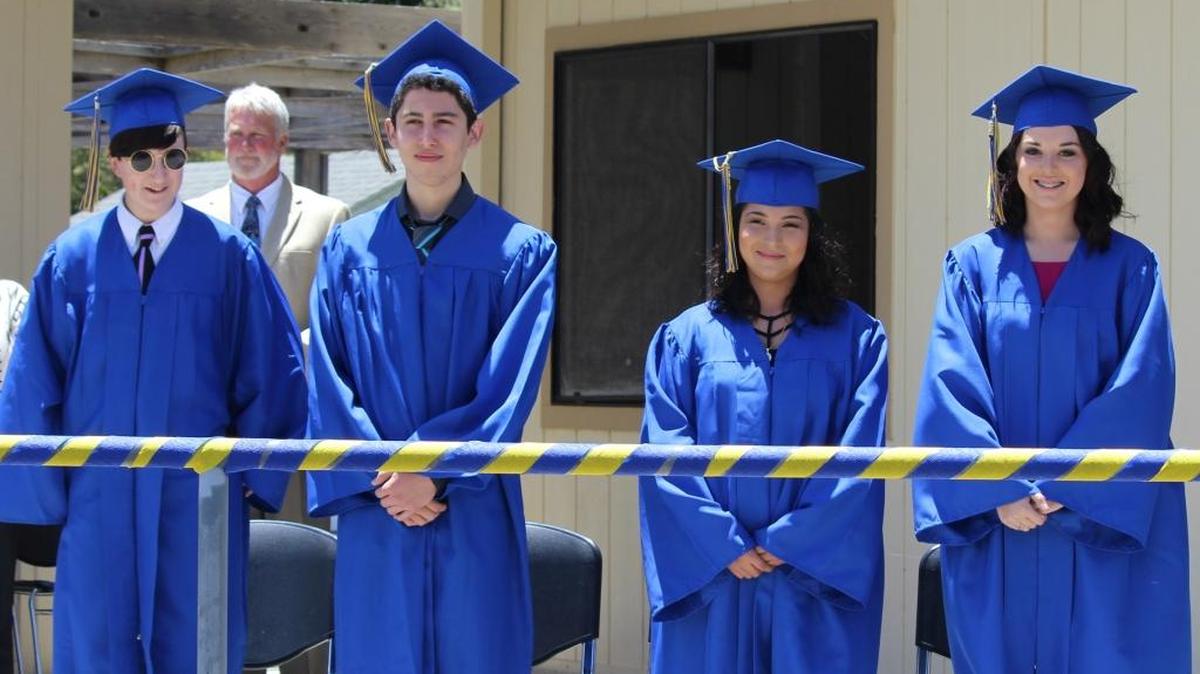 Graduates, from left, Emily White, Eduardo Paz, Maria Jacobo and Rebecca Adams stand after taking the stage for the graduation ceremony Wednesday, June 8, at Leffingwell High School.