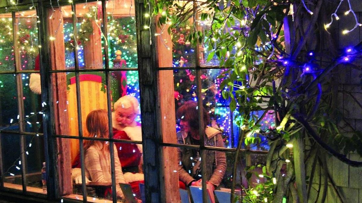 Santa visits with a girl inside his workshop at last year’s Cambria Christmas Market.