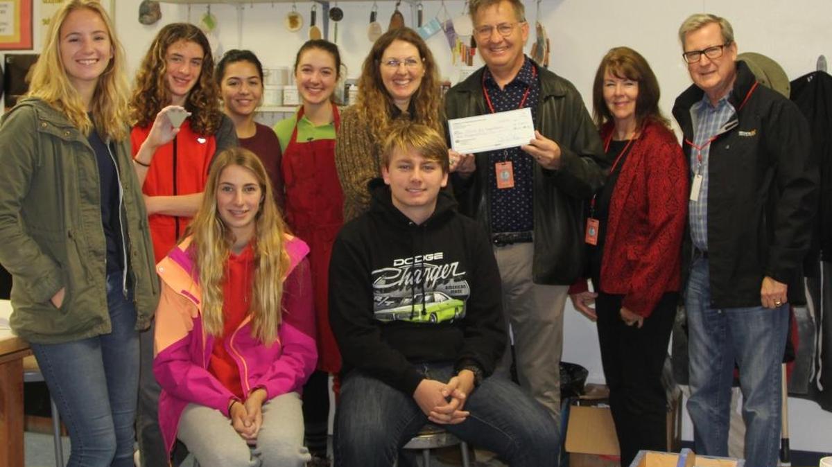 Scarecrow Festival President Dennis Frahmann, holding the check, presents Coast Union High School art instructor Suzette Morrow, center rear, with a donation of $4,050 to support the school’s art programs.