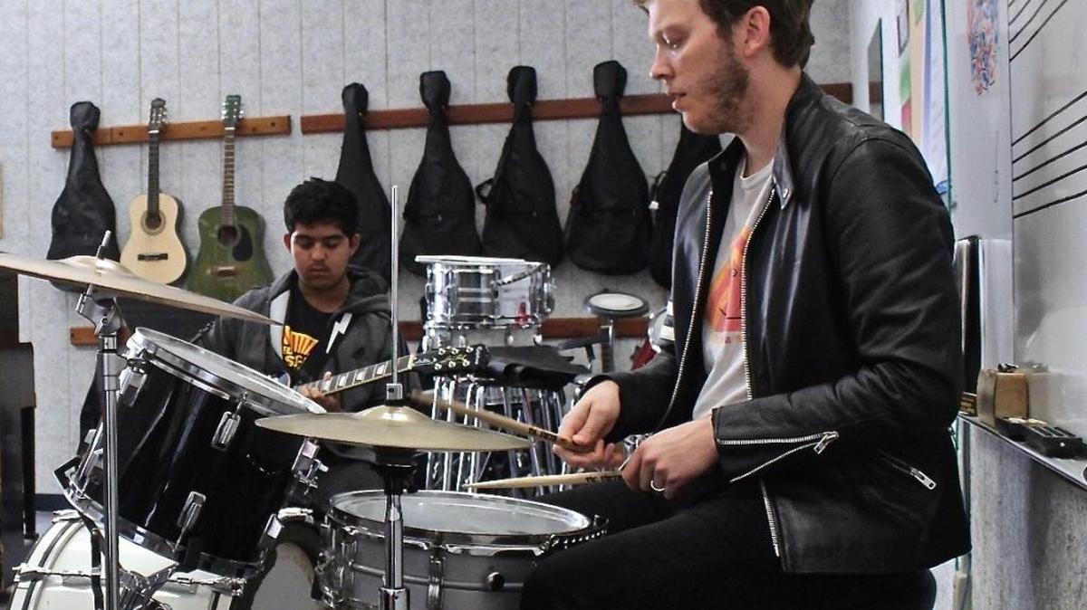 Coast Union junior Giovanni Espinoza, left, jams on guitar with his music instructor, Jonathan Mattson, at the high school recently.