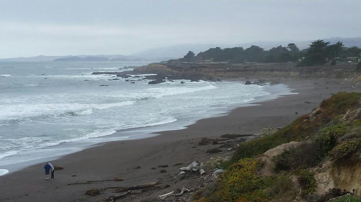 A solitary pair of visitors enjoy Moonstone Beach on Monday, Oct. 30, with Leffingwell Point in the distance.