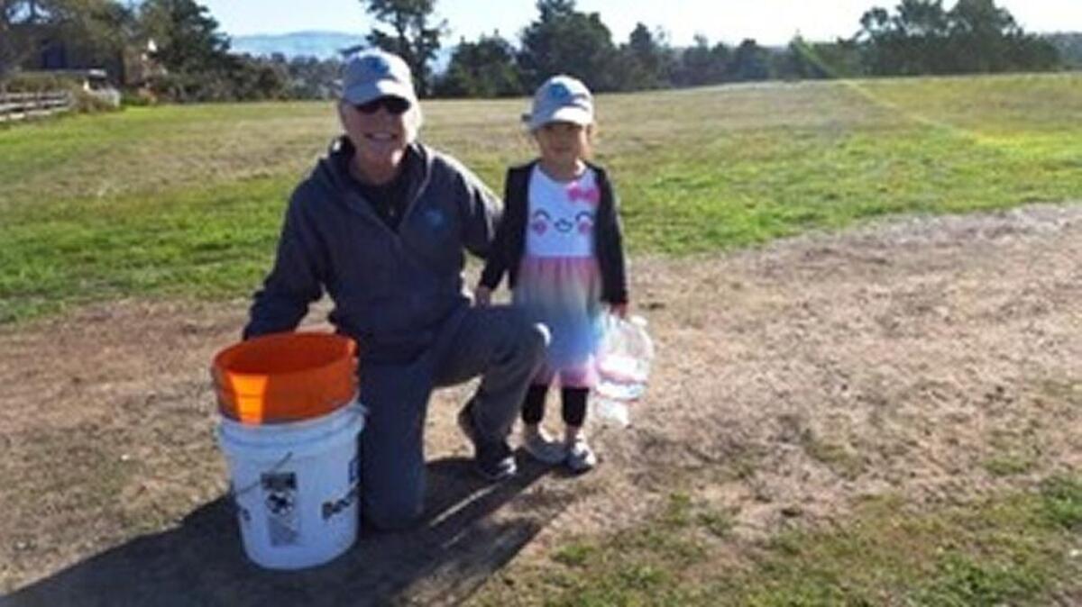Bruce Mumper, North Coast Advisory Council environmental representative, volunteers with granddaughter Cambrielle.