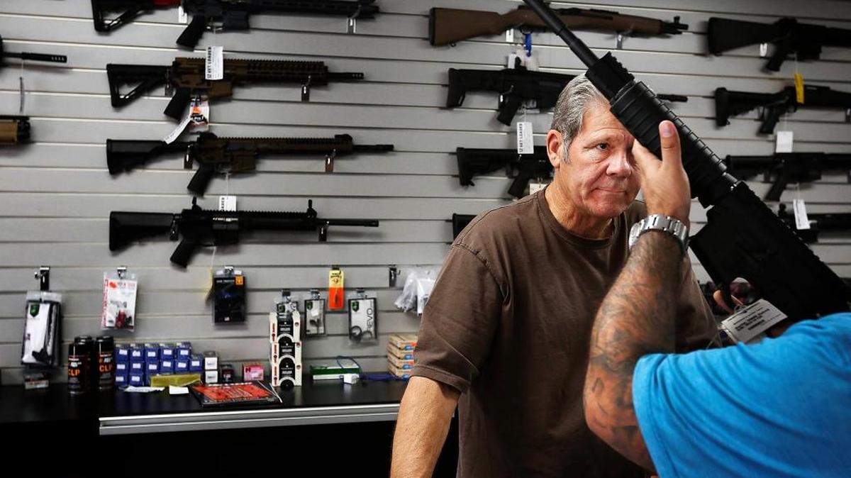 Gunsmith Frank Cobet of the Get Loaded gun store in Chino shows a customer an AR-15 rifle Dec. 8.