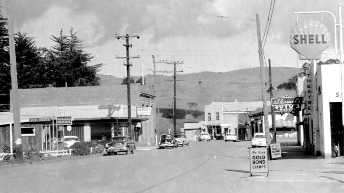 The old Cambria Theater (with the sign spelled “THEATRE”) is visible just past the Shell sign in this 1956 photo.