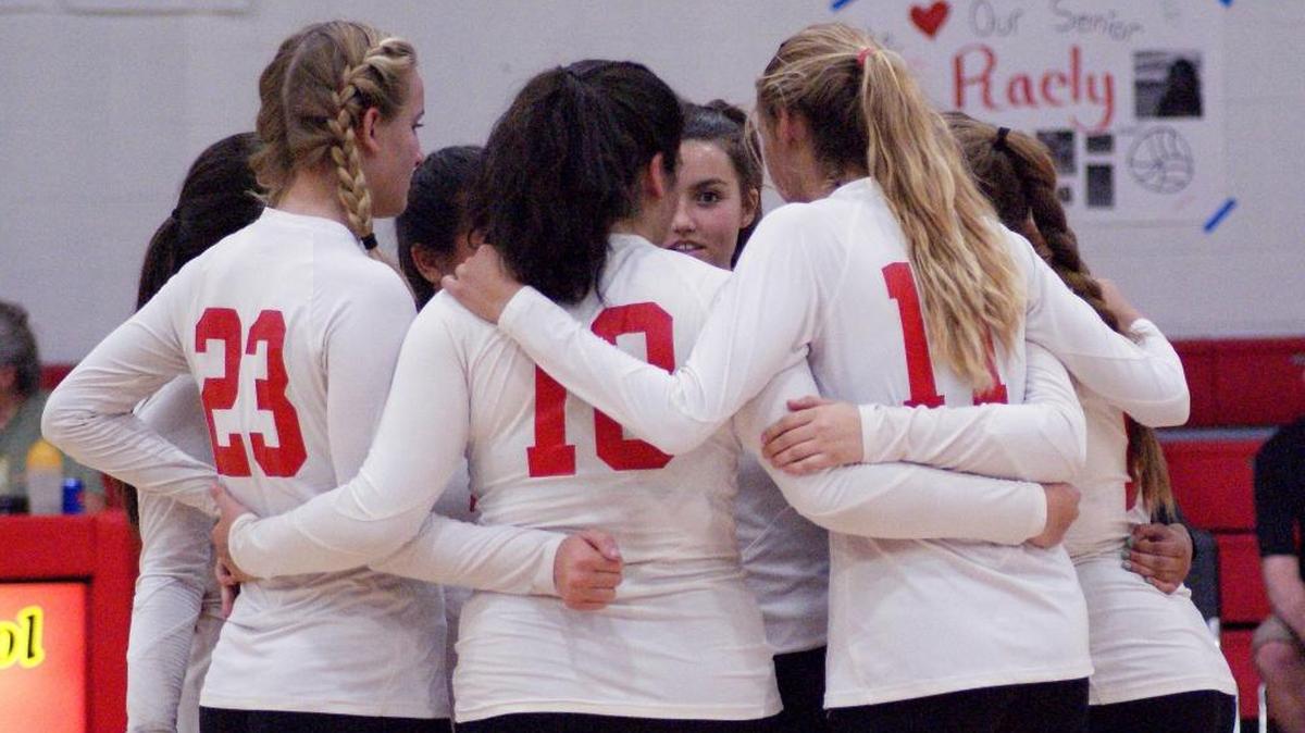 Coast Union volleyball players huddle during a late-season match. The team went undefeated in league play to win the Coast Valley League championship.