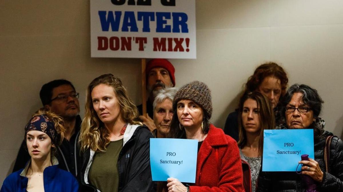Supporters of the Chumash Heritage National Marine Sanctuary hold signs during the San Luis Obispo County Board of Supervisors meeting on Feb. 7.