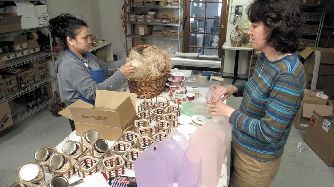 Rosa Hernandez, left, and Terreca Lindsay, right, prepare for the holiday season in 2002 with baskets Olalliberry preserves Linn’s Warehouse.