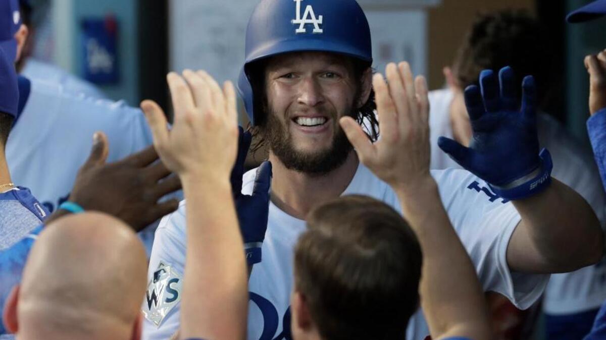 Los Angeles Dodgers pitcher Clayton Kershaw is greeted with in the dugout after a succesful sacrifice bunt against the Houston Astros in Game 1 of the World Series at Dodger Stadium in Los Angeles on Oct. 24. Kershaw is unusual in that he’s spent his entire career, 10 years and counting, with the same team so far.