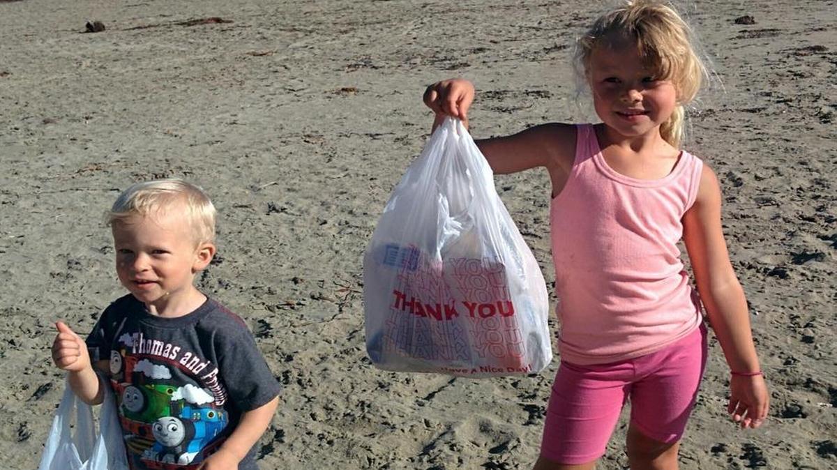 Holly Smirl’s grandchildren, Sutter and Peyton, clean up trash on the beach in Cayucos.