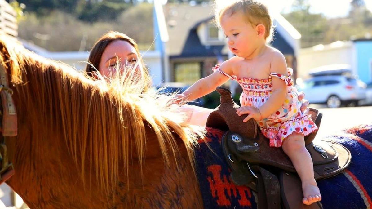 Cadence Yaple Vanicky saddles up at her first birthday party Old Stone Station on Main Street. Cadence, the daughter of Old Stone Station owners Carrie Yaple and Carl Vanicky, comes from a long line of women who are horse lovers.