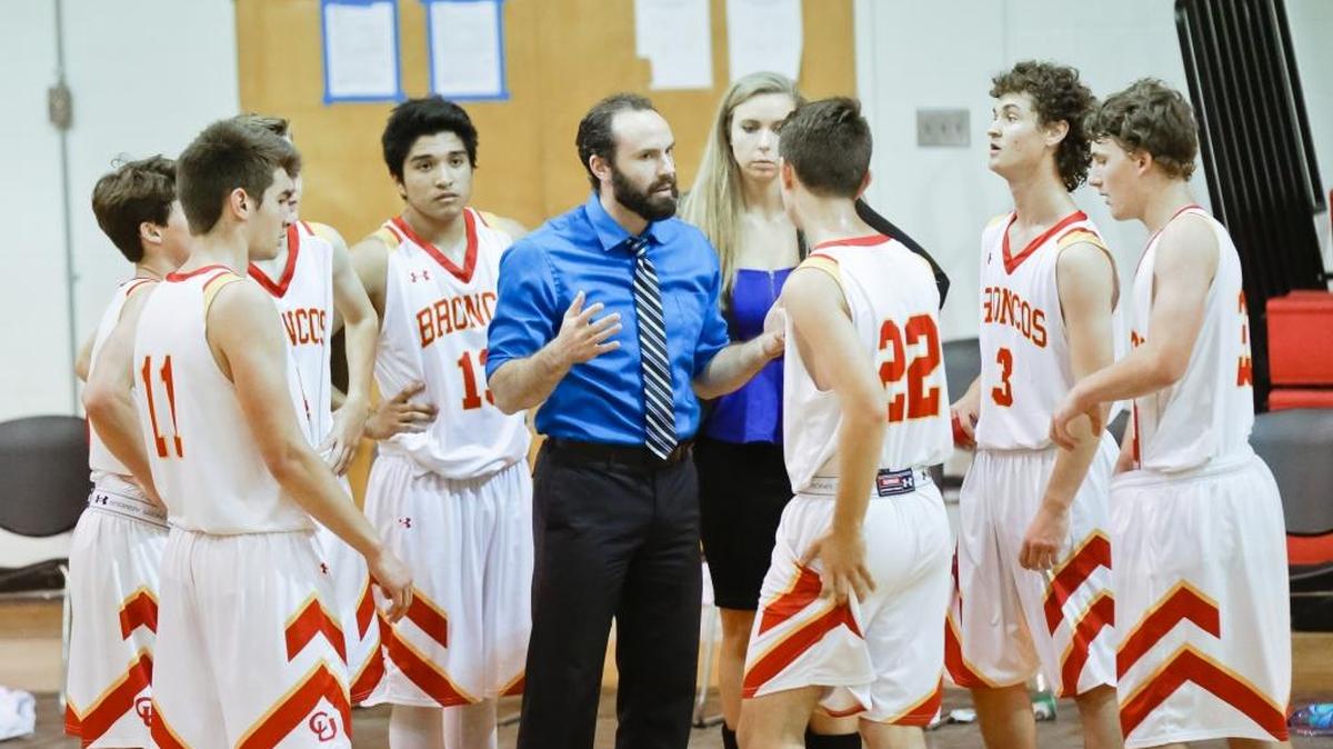 Head coach Tim May talks with his players during a game in February. The Broncos team was named “Academic Champion” by CIF for high scholastic achievement.