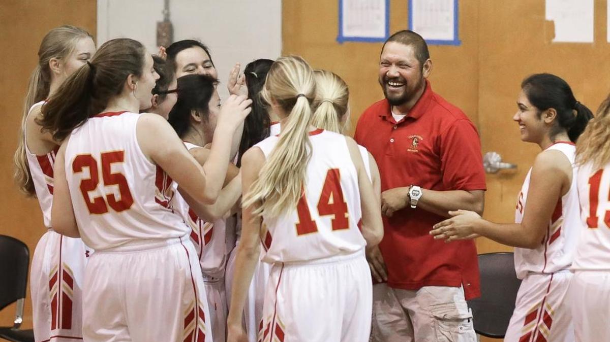 Girls head coach Bobby Youngs celebrates with his team after defeating Coastal Christian on Feb. 9, the last game of the regular season.
