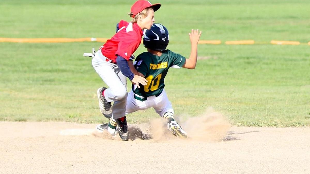 Cambria Reds infielder Ethan Hoffman puts a late tag on a Los Osos A’s player who was safe at second base.