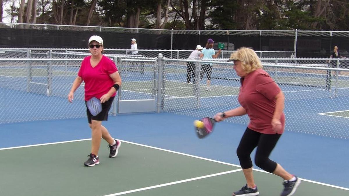Barbara Forgey, right, returns a serve, with doubles partner Mary Middleton looking on Monday, July 18, at the Cambria Pickleball Club’s courts behind the Old Grammar School.