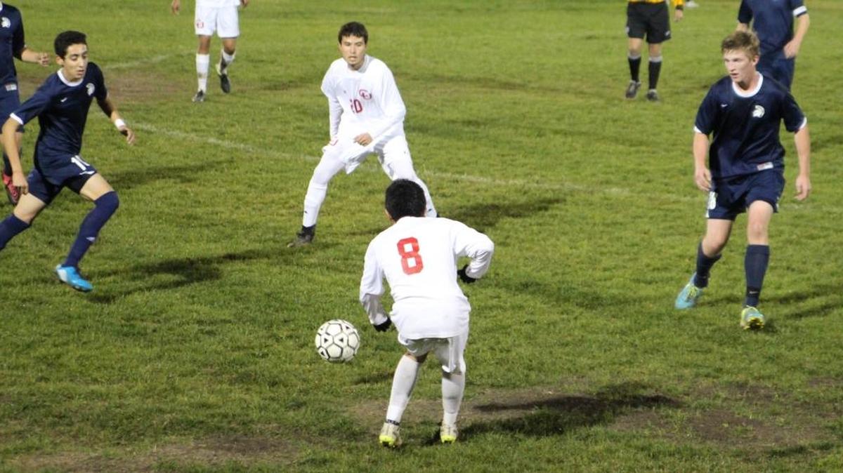 Danny Pena, foreground, passes the ball to Luis Alberto Lizaola against Orcutt Academy on Dec. 8. Orcutt won 5-0.