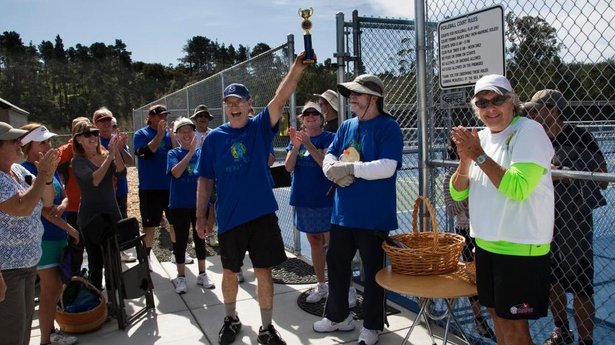 Kathryn Thomas, far right, awards the tropy to Phil Sumner, captain of the Cambria pickleball team, at the conclusion of the Coast Cup Challenge.