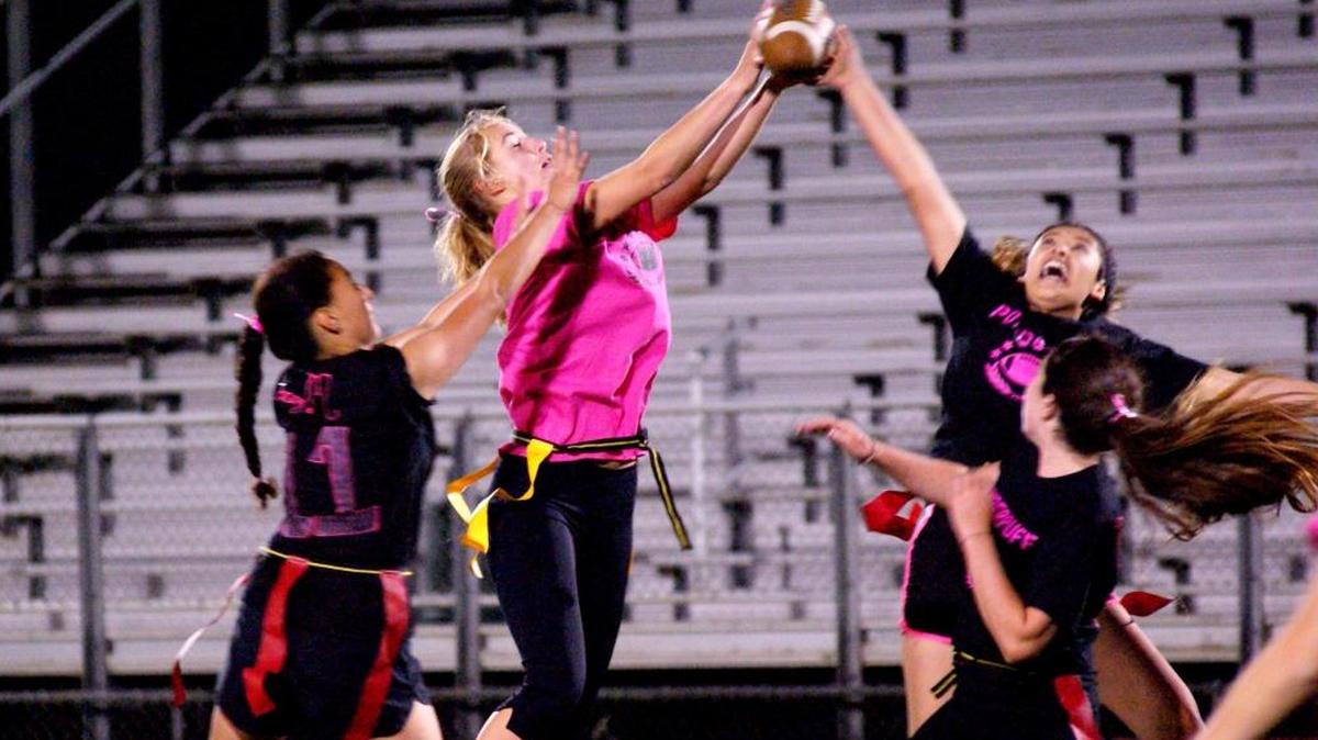 The varsity boys football game may have been canceled, but the annual Coast Union Powder Puff football game, part of homecoming festivities, was held Wednesday night, Oct. 4. Martha Gomez, far left, Ellie Kennedy in pink shirt, and Ashley Colin reach for the ball as Zoe Markham looks on. The junior and senior girls beat the underclassmen 12-0.