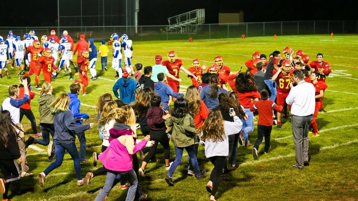 Students run onto the field to congratulate the Coast Union football team after its first win of the season, a 25-14 victory over Valley Christian Academy on Oct. 14.