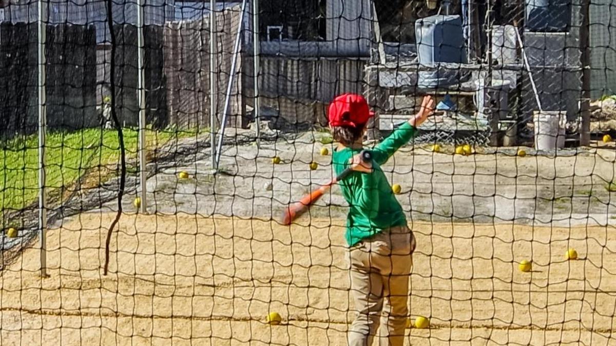 Cambria Reds Little League player Robert Saunders takes some cuts in the Kniffen batting cage on Kerry Street after the Lions Club of Cambria purchased a new net for the facility. Eli Linn, also a Reds player, is feeding baseballs into the pitching machine.