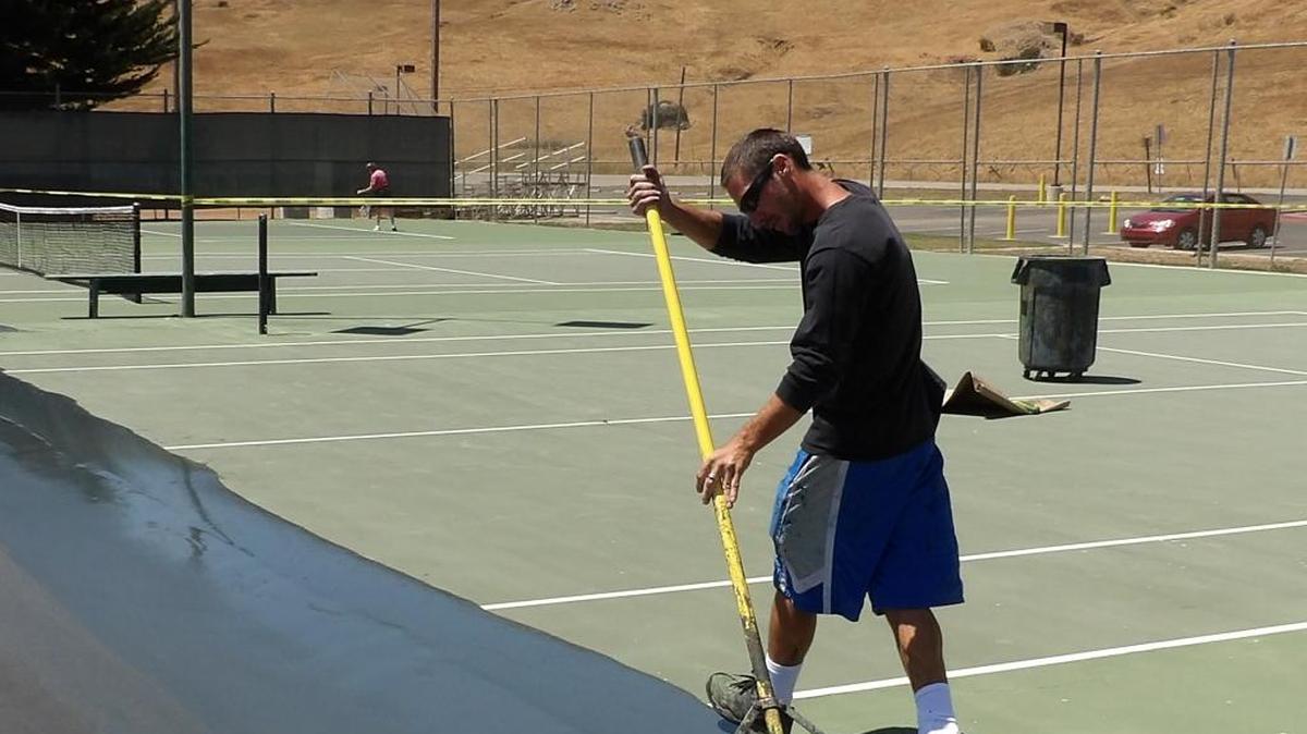 Tennis court specialist Jeremy Wendel, who works for First Serve, lays down the final coat of green acrylic paint on Court 2 at Coast Union High School on Thursday, July 7.