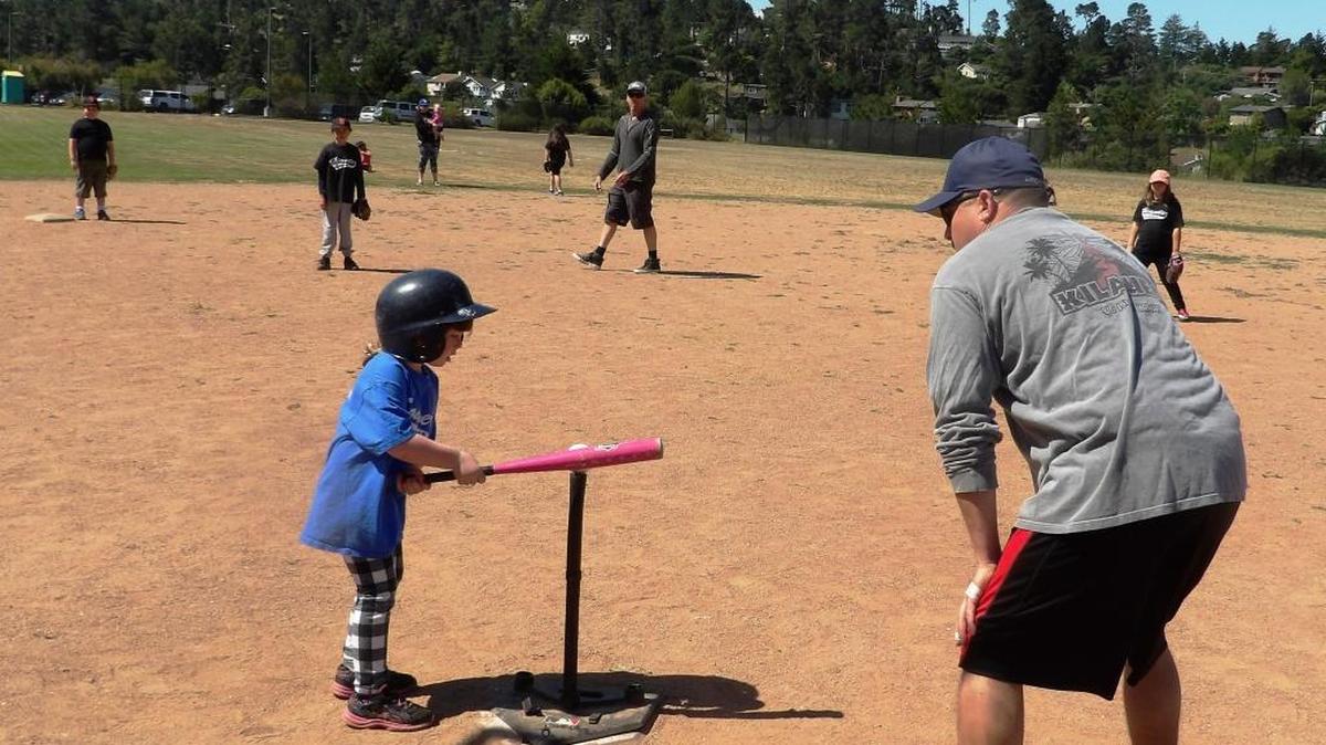 Coach Trenton Salin provides guidance for batter Emma Fields at the CYAA T-ball game Saturday, May 27, at the Cambria Grammar School.