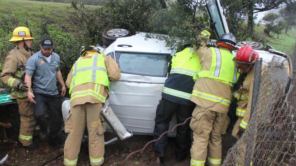 Rescue personnel work to get the lone occupant out of a car that rolled down an embankment off Highway 1 and came to rest across from the Shell station in Cambria’s West Village about 2:50 p.m. Sunday. Michelle Renee Latham received minor injuries.