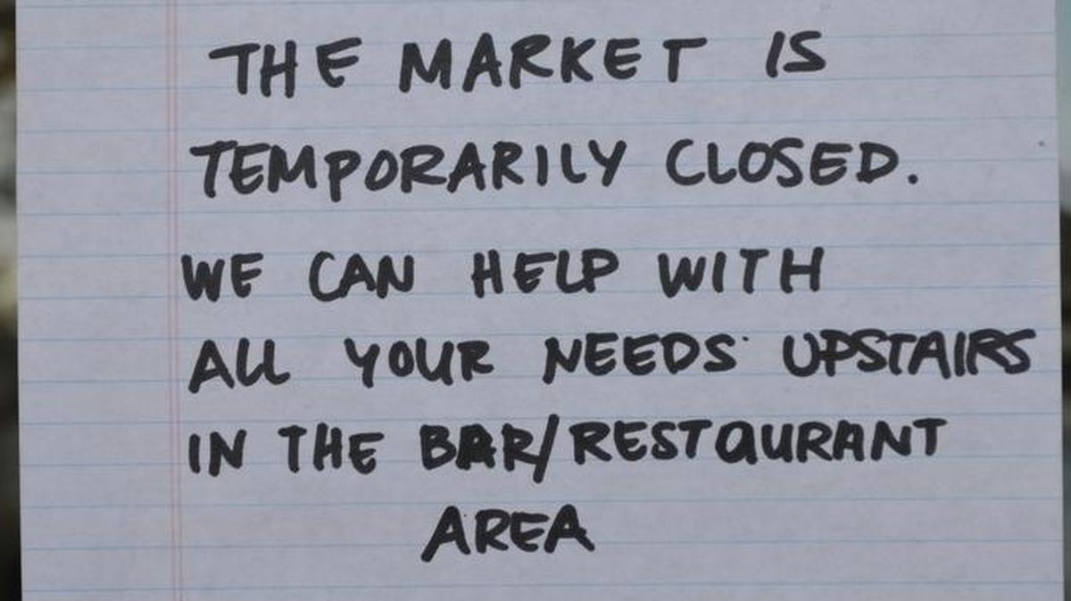 A handwritten sign on the door of Centrally Grown told customers the market was temporarily closed Saturday.