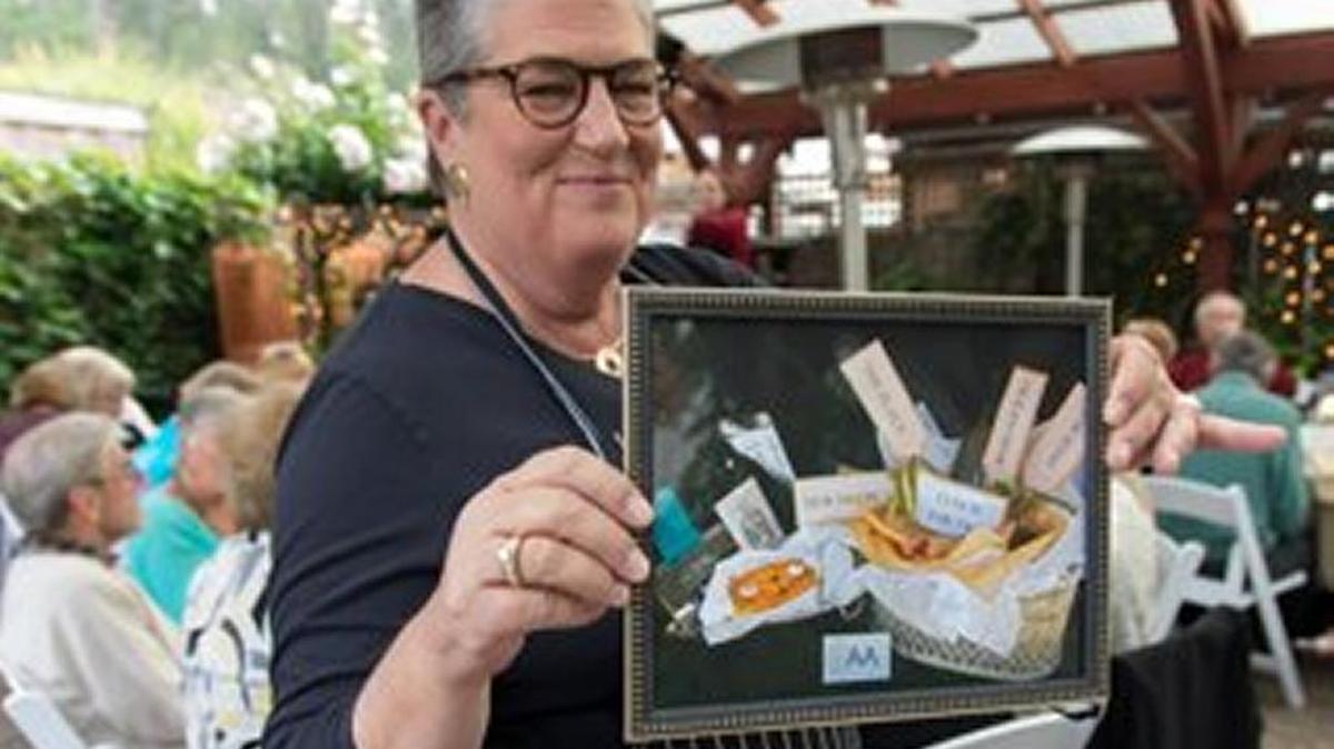 At last year’s Wines, Pines and Felines event, HART’s very own Vanna, Suzy Siegler, displays a photo of an auction package for bidders’ consideration.