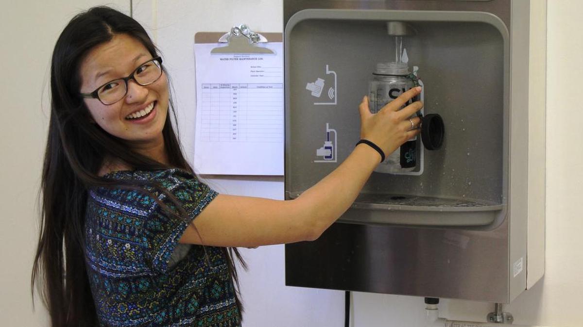 Coast Union valedictorian Xue DiMaggio, who led the drive for new water bottle refilling stations, does the honors Monday in the high school cafeteria.