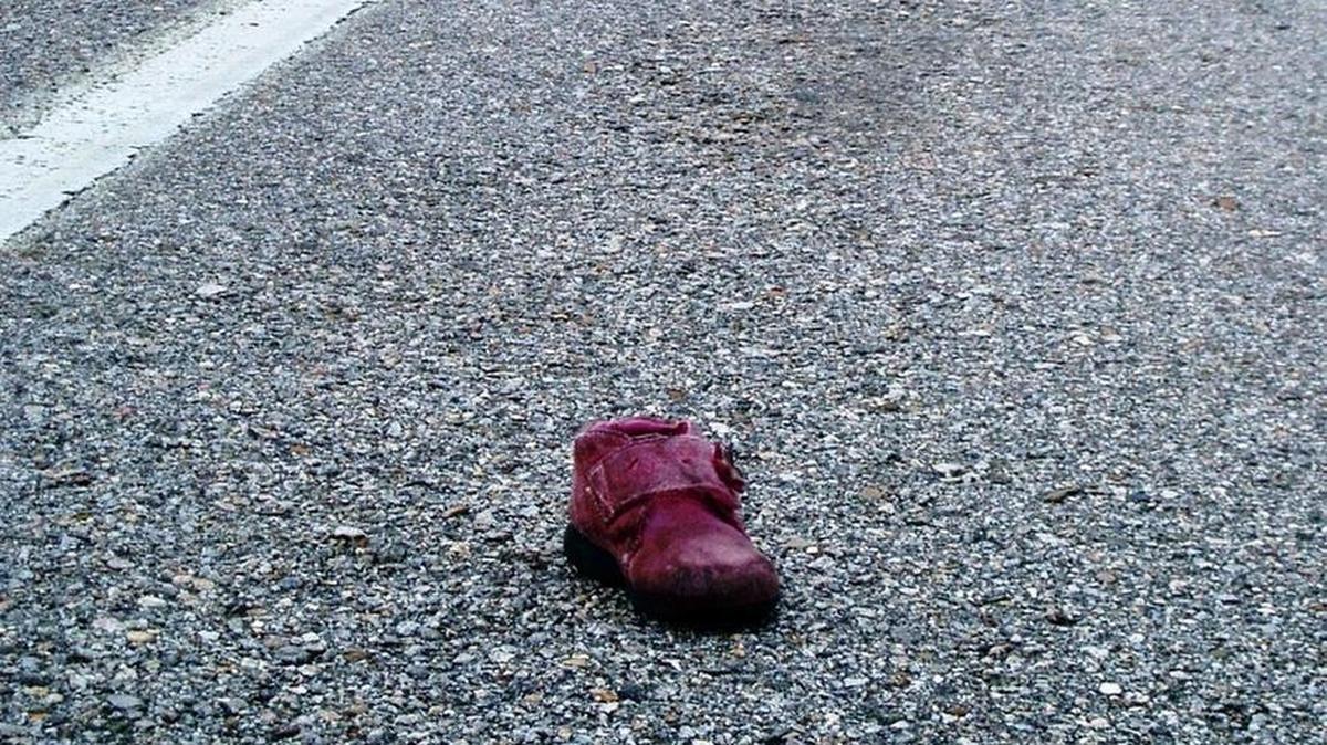 Discarded items along the side of the highway can range from sofas to plastic containers to shoes, like the one pictured.