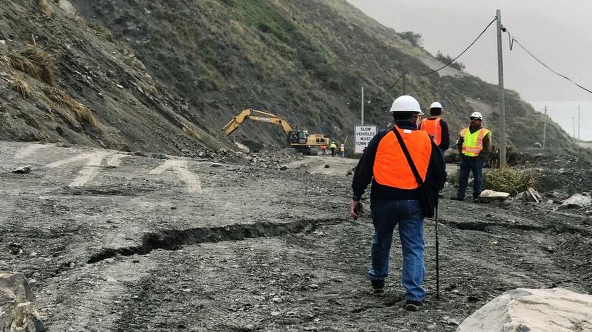 Workers survey the Mud Creek slide on Highway 1.