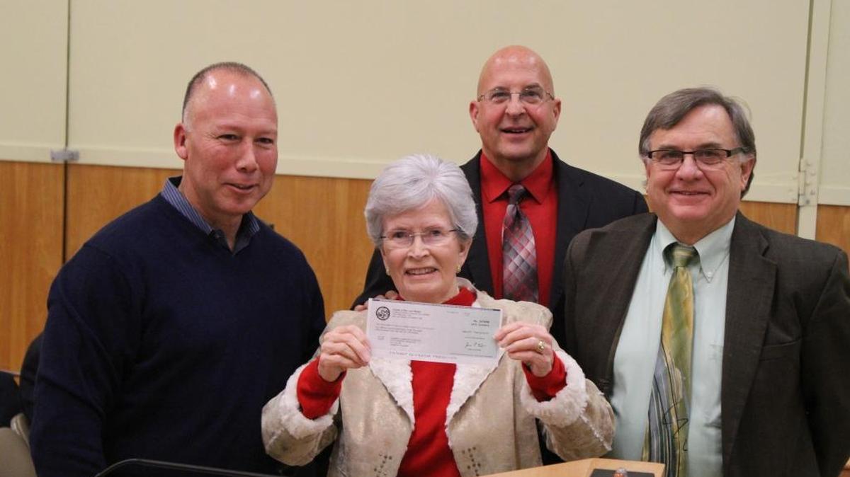 CCSD board President Gail Robinette holds up a check for $4.16 million presented by Dean Florez, left, at the board’s Dec. 17 meeting that will help the district pay for its new water plant. Also pictured: General Manager Jerry Gruber, rear, and District Engineer Bob Gresens, right.