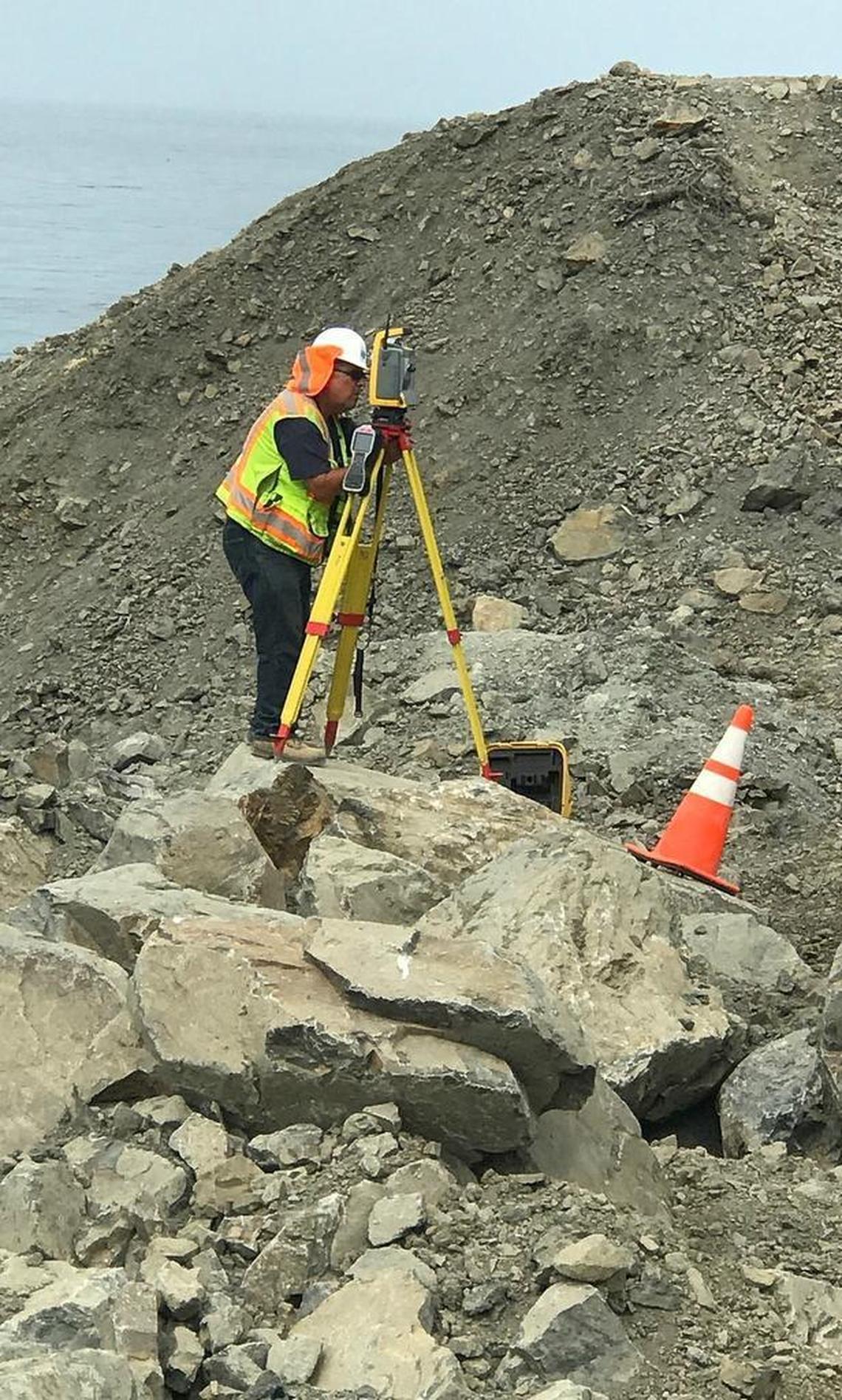 A surveyor keeps his eye on the scarp (hillside) from equipment stationed at the toe of the Mud Creek Slide early this month.