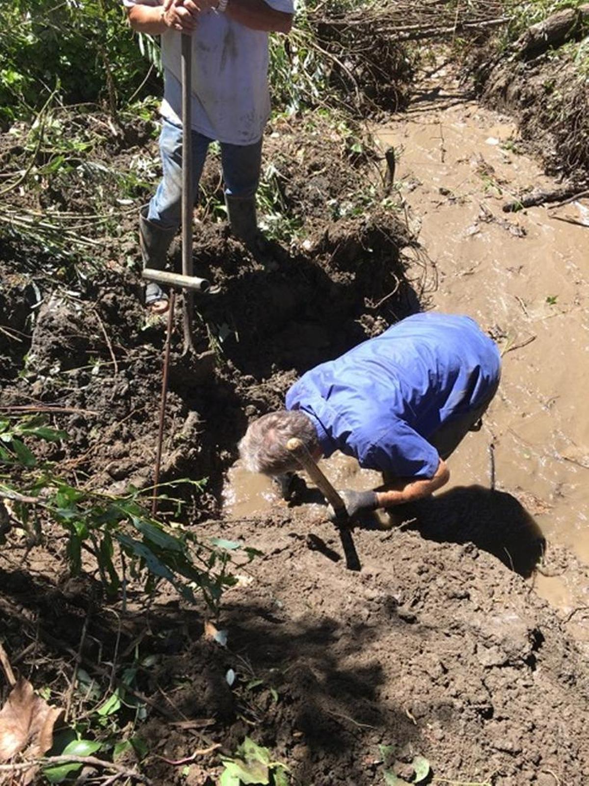 Workers had to wade through mud to get at the leak Monday.