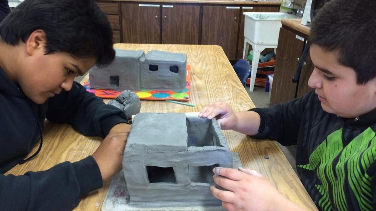Seventh-graders Bibiano Mercado, left, and Jose Alcantar work on a gnome house for the Santa Lucia Middle School garden.