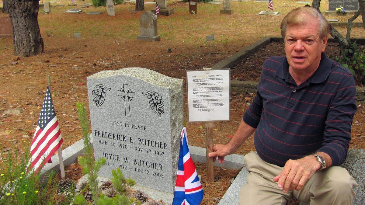 Howard Butcher poses for a picture by his parents' grave at the Cambria Community Cemetary. The gravesite has been vandalized multiple times since 2015.