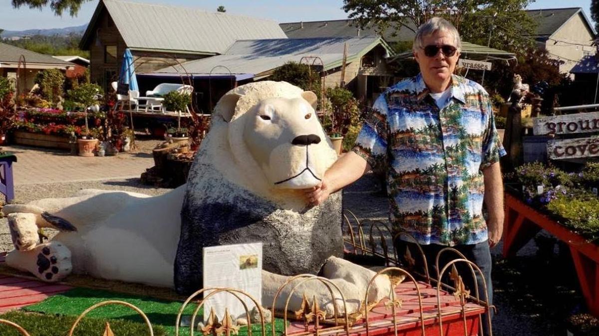 Terry Camp shows off his leonine scarecrow entry, Cecil, at Cambria Nursery.