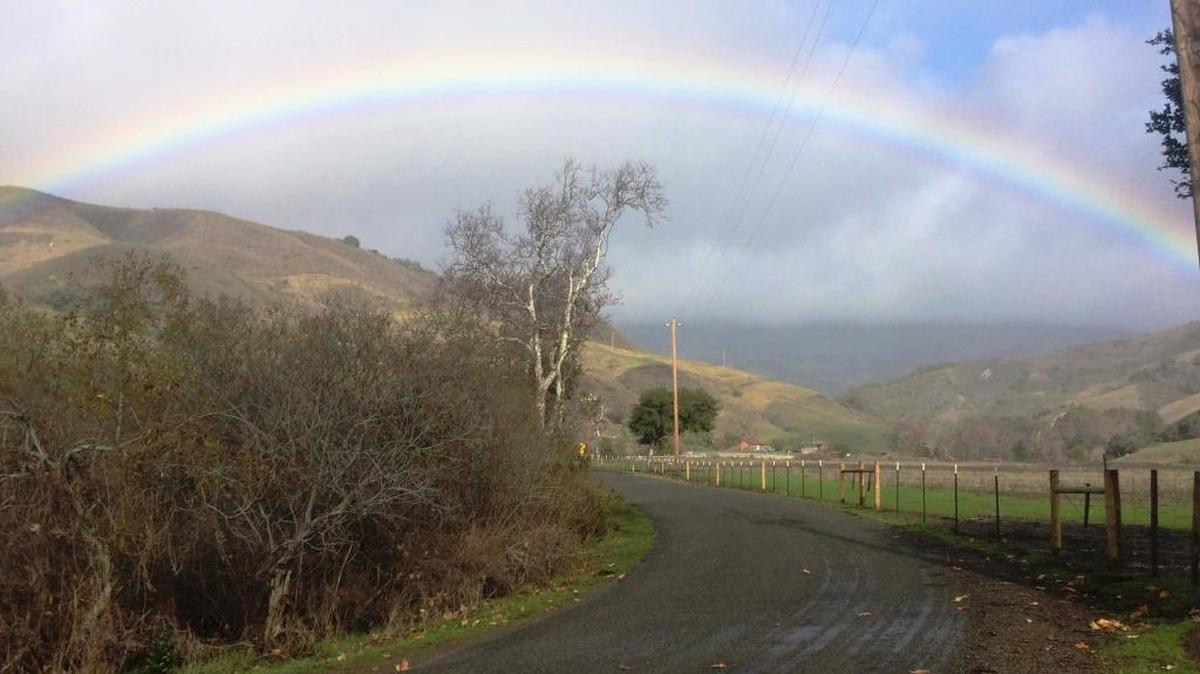 A rainbow stretches across San Simeon Creek Road on Jan. 5.