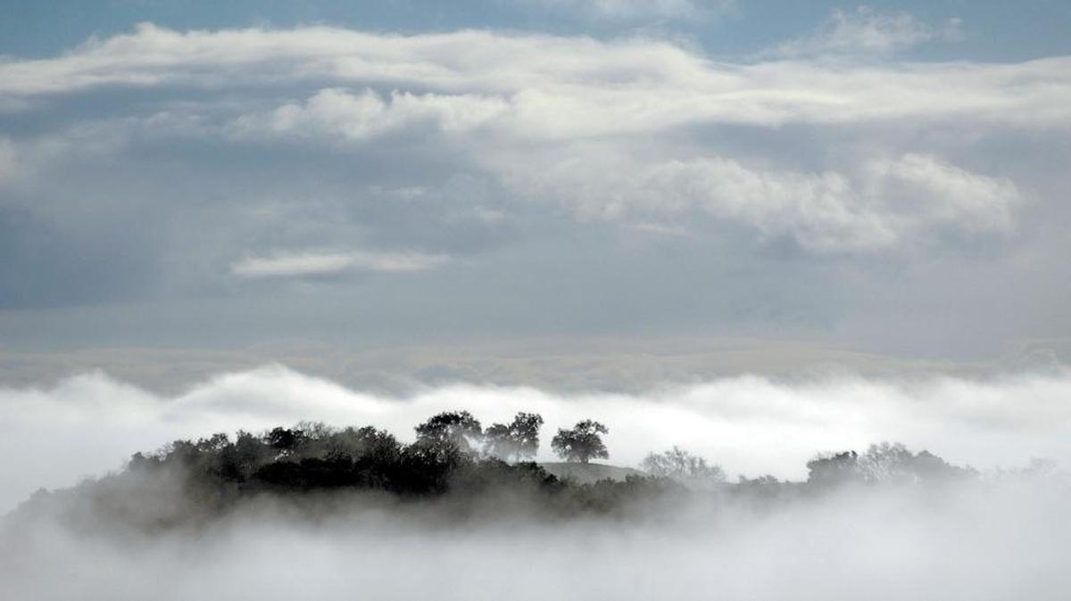 A ridge makes an island in the clouds off of Highway 46 West as the sun comes up and fog fills the Salinas River Valley in this photo from February 2006.