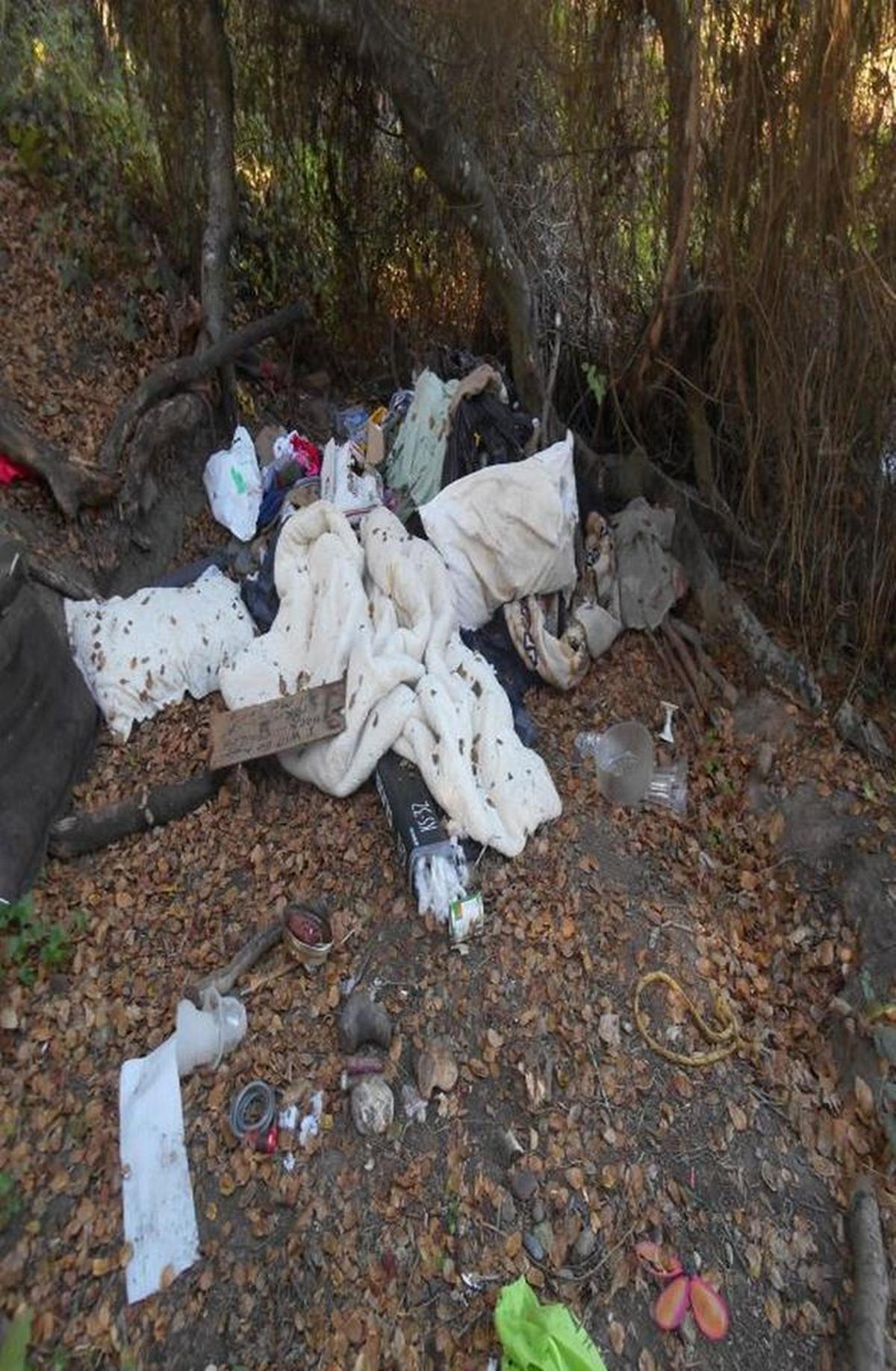 Trash is shown piled up in a homeless encampment recently in Cambria.
