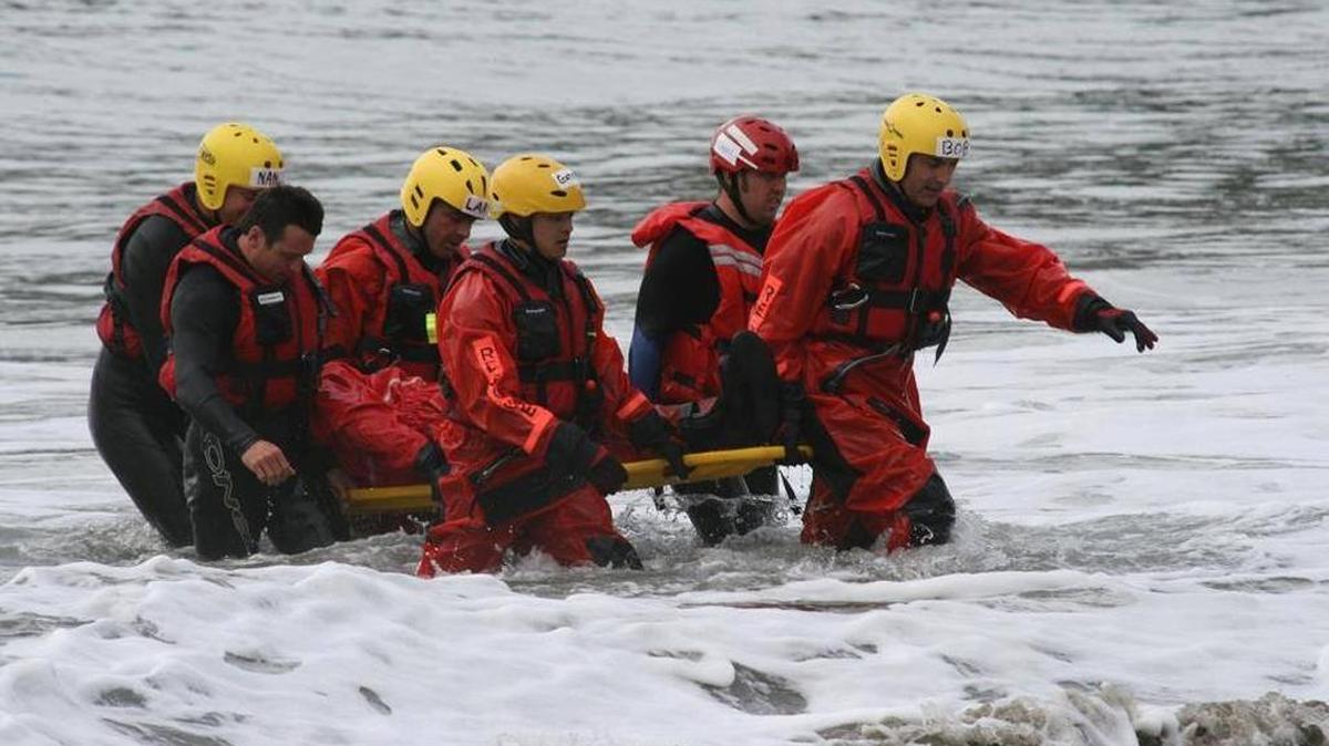 Members of a surf rescue class practice open-water rescue techniques in 2009 at San Simeon Cove.