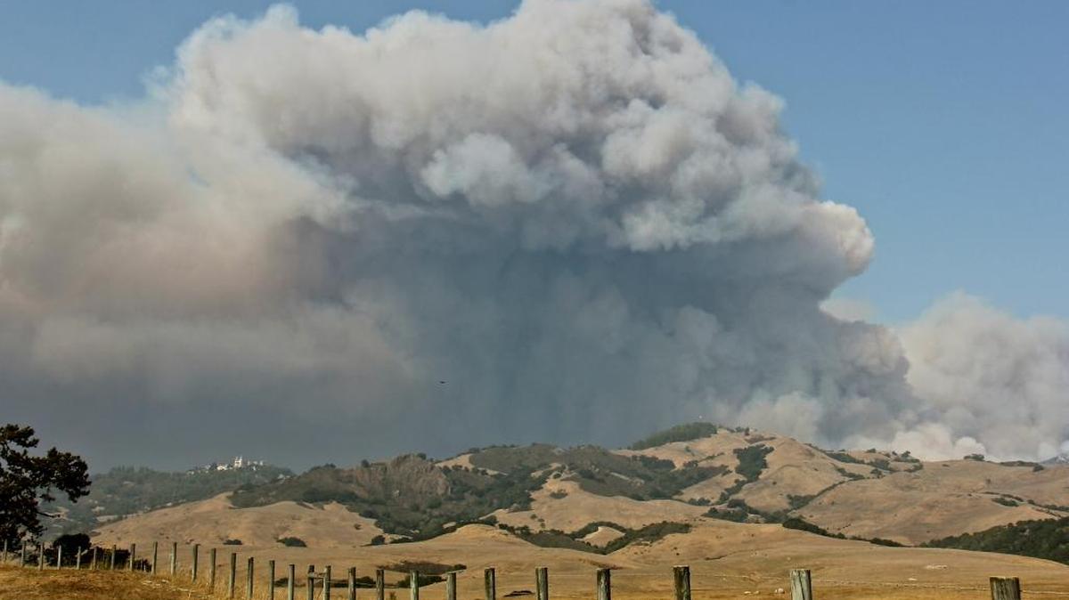 Smoke from the Chimney Fire rises from behind Hearst Castle, seen in the distance at upper left.