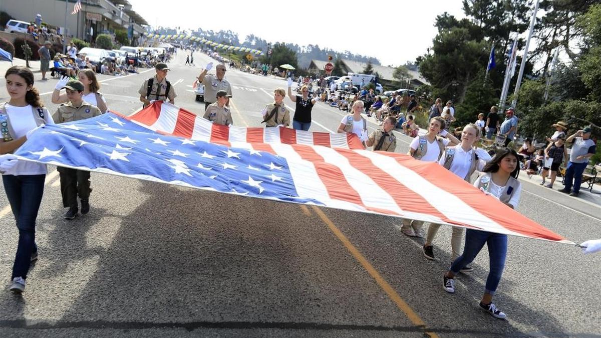 Cambria Girl and Boy Scouts and 4H kids walk with a large American flag during last year’s Pinedorado Parade.