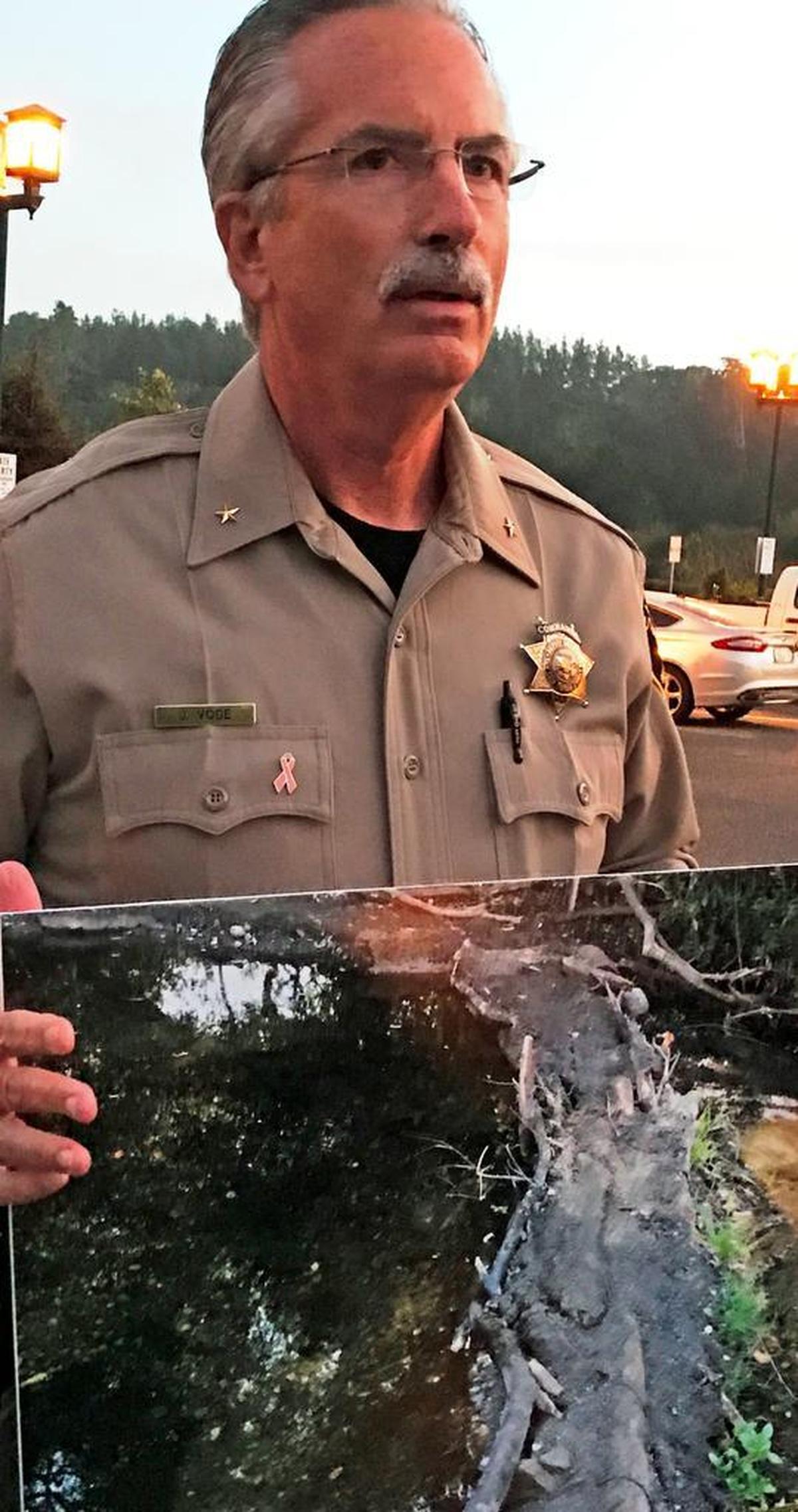 Sheriff’s Cmdr. Jim Voge holds a photo of a dam built across Santa Rosa Creek at a homeless encampment.