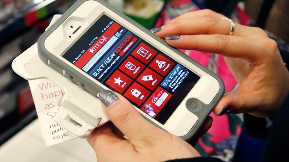 Tashalee Rodriguez of Boston uses a smartphone app while shopping at Macy’s in downtown Boston in 2012.