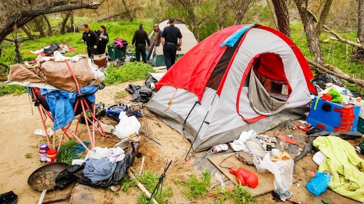 Members with the Paso Robles Police Department make contact with folks living in a homeless camp along the Salinas riverbed in early March to warn them of the upcoming cleanup of the camps.