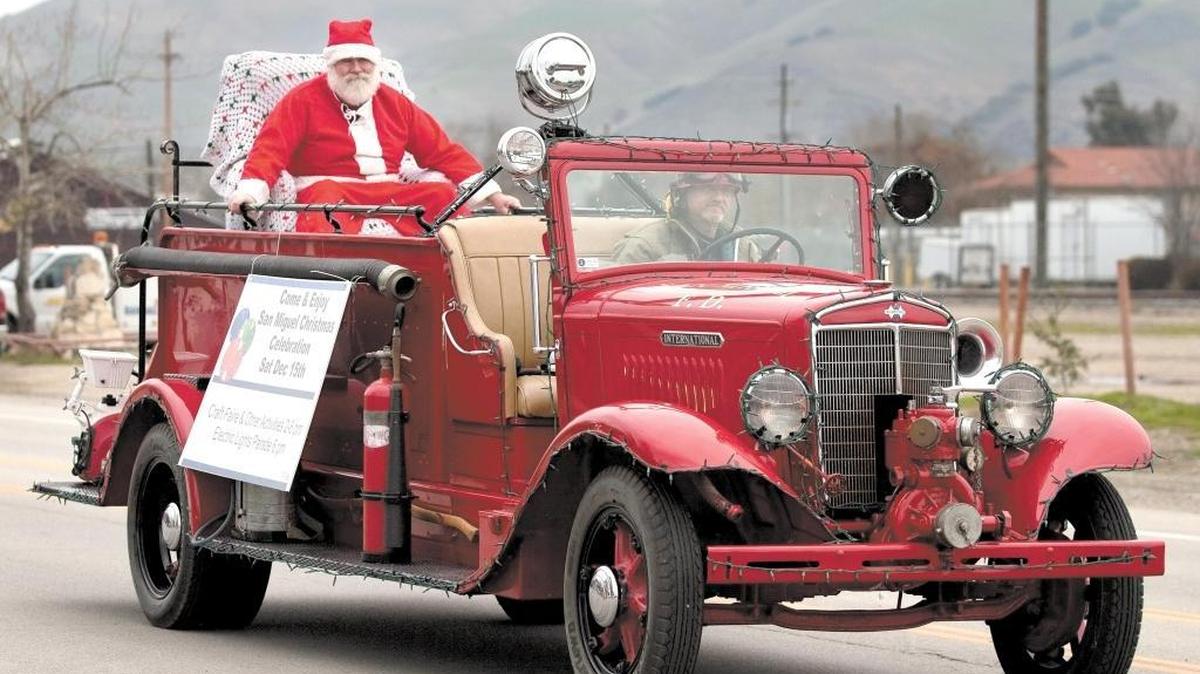 Santa Claus hitches a ride through town in an old-fashioned fire truck during the holiday Christmas parade in San Miguel in 2012.